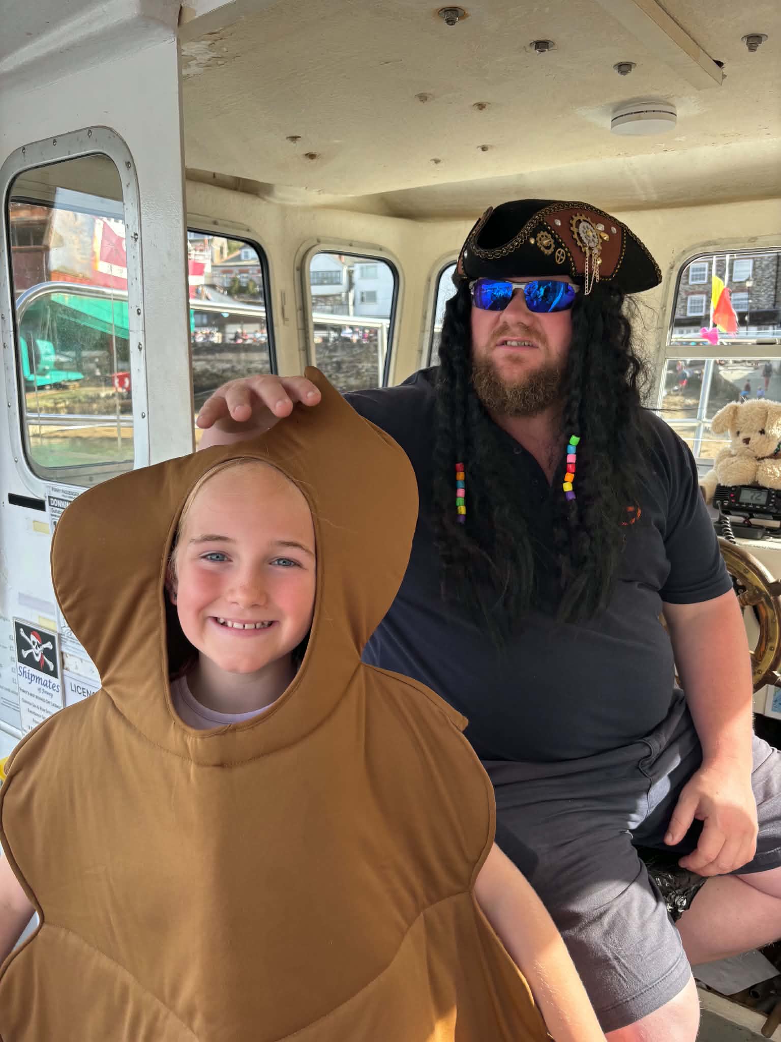 Young carnival entrant in fancy dress visiting a pirate aboard a harbour boat