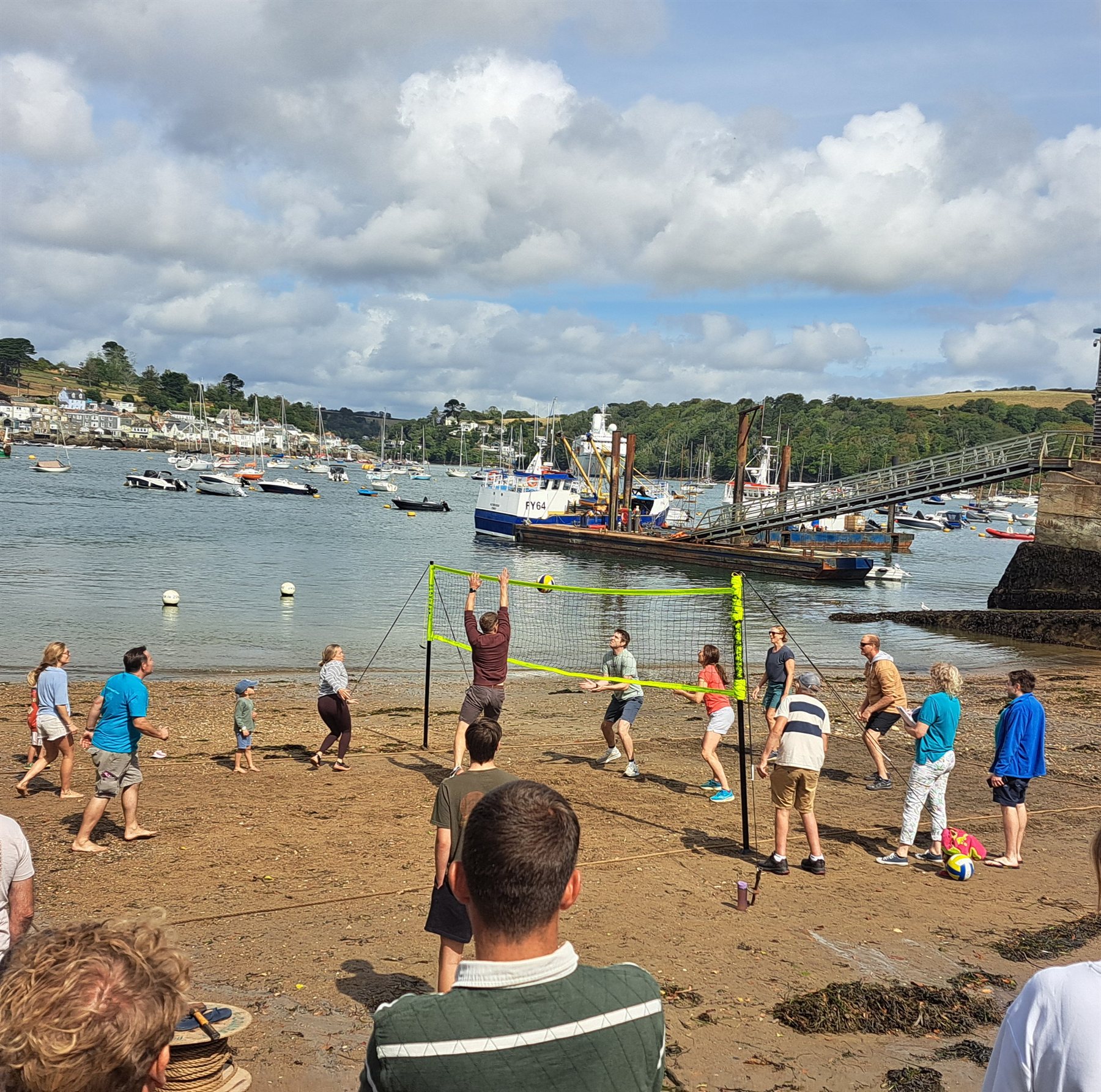 Beach volleyball in Polruan harbour with Fowey and moored boats beyond