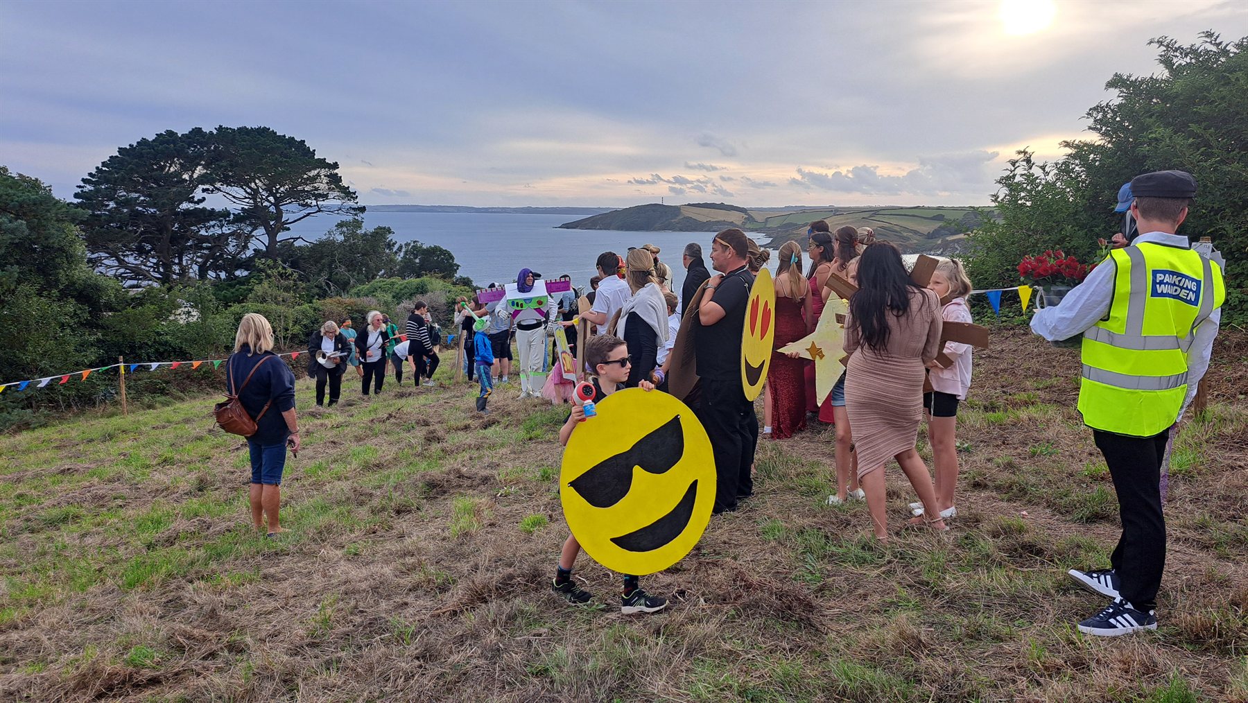 Colourful carnival entrants gathered on the hillside above the Cornish coast