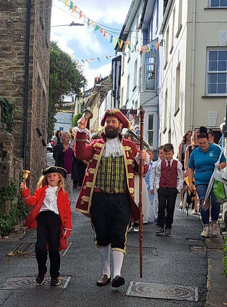 Town crier and a young bell-ringer leading the 2026 procession
